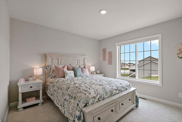 bedroom with baseboards and light carpet