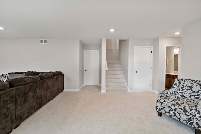 living area with recessed lighting, baseboards, visible vents, and light carpet
