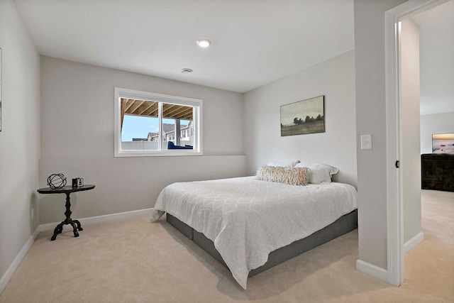 bedroom with baseboards and light colored carpet