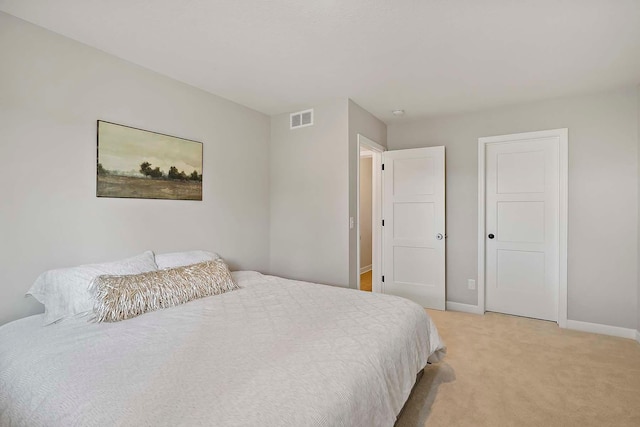 bedroom with visible vents, baseboards, and light carpet
