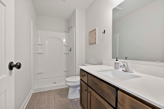 full bath with vanity, walk in shower, and toilet