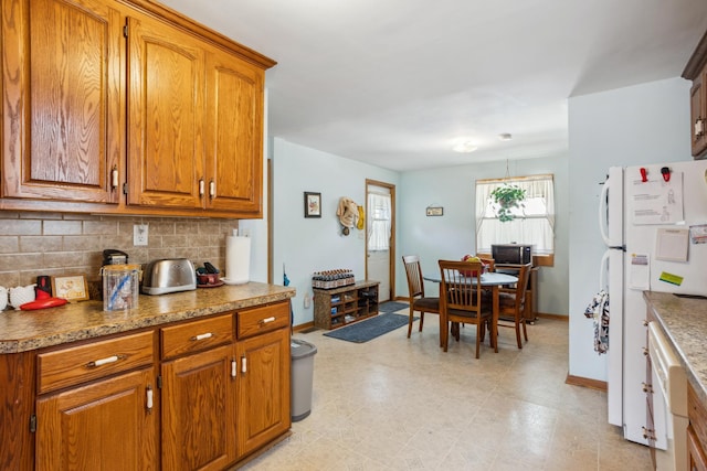6021 10th Ave S, Minneapolis, MN 55417 - kitchen with freestanding refrigerator, backsplash, brown cabinets, and baseboards