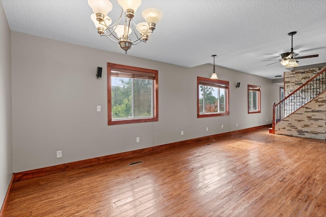 28008 Lake Diann Rd, Baldwin Twp, MN 55398 - unfurnished living room featuring stairs, plenty of natural light, a textured ceiling, light wood finished floors, and a chandelier