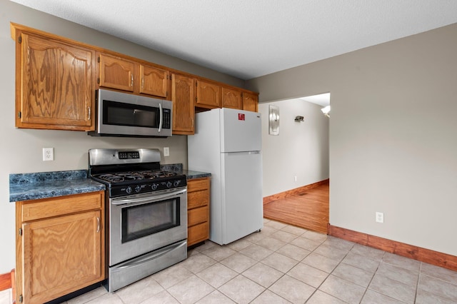 28008 Lake Diann Rd, Baldwin Twp, MN 55398 - kitchen featuring appliances with stainless steel finishes, dark countertops, and brown cabinets