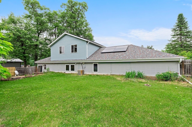 28008 Lake Diann Rd, Baldwin Twp, MN 55398 - back of house with roof mounted solar panels, a fenced backyard, and a shingled roof