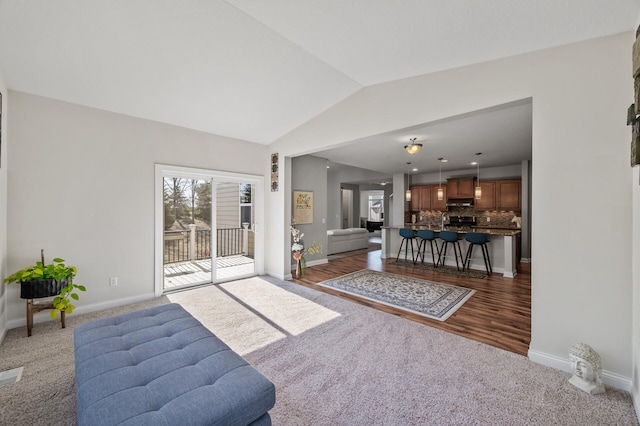 living area with carpet flooring, baseboards, and lofted ceiling