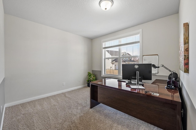 office area with a textured ceiling, baseboards, and carpet