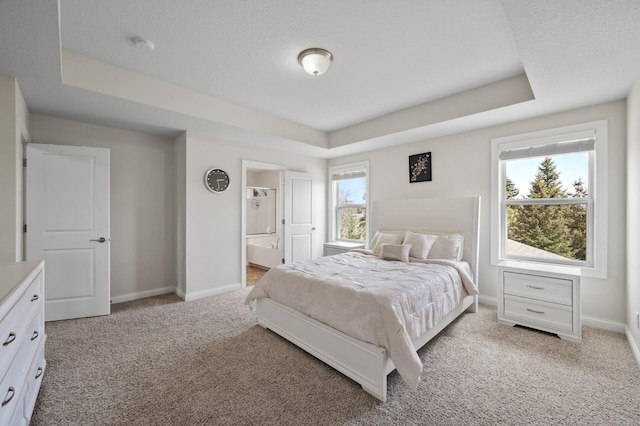 bedroom with baseboards, light carpet, and a raised ceiling