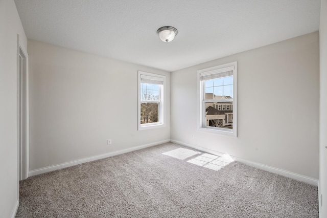 carpeted empty room with baseboards