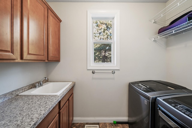 laundry area with cabinet space, a sink, separate washer and dryer, baseboards, and visible vents