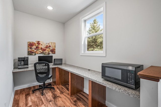 office featuring baseboards, built in desk, recessed lighting, and wood finished floors