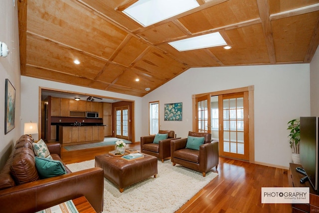 living room featuring recessed lighting, wood finished floors, wooden ceiling, lofted ceiling with skylight, and baseboards