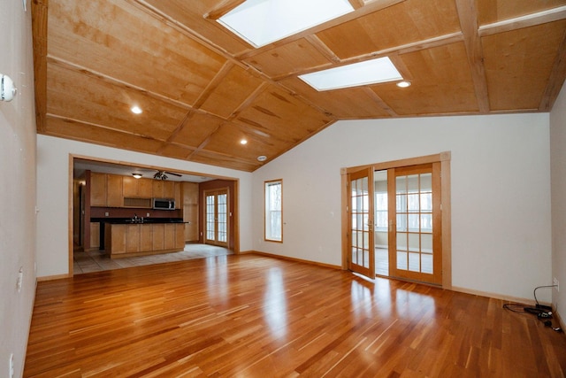 unfurnished living room featuring wood ceiling, baseboards, and light wood-style flooring