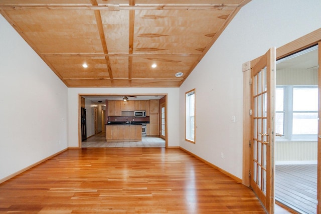 unfurnished living room with baseboards, light wood finished floors, wooden ceiling, and french doors