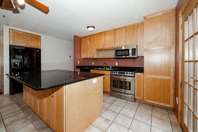 kitchen with ceiling fan, dark countertops, appliances with stainless steel finishes, and light tile patterned flooring