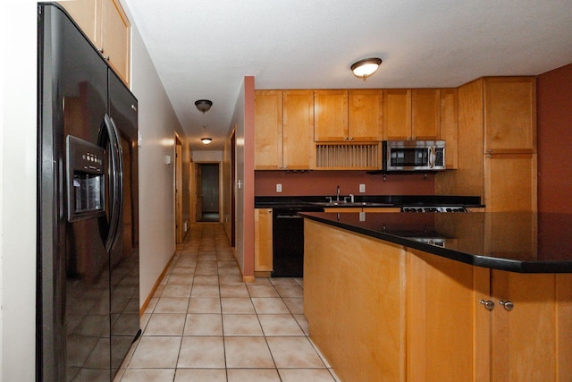 kitchen featuring dark countertops, a sink, black appliances, brown cabinets, and light tile patterned floors