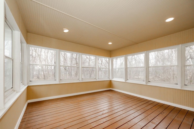 unfurnished sunroom with baseboards, recessed lighting, and wood-type flooring