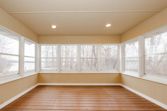 unfurnished sunroom with wood-type flooring, baseboards, and recessed lighting