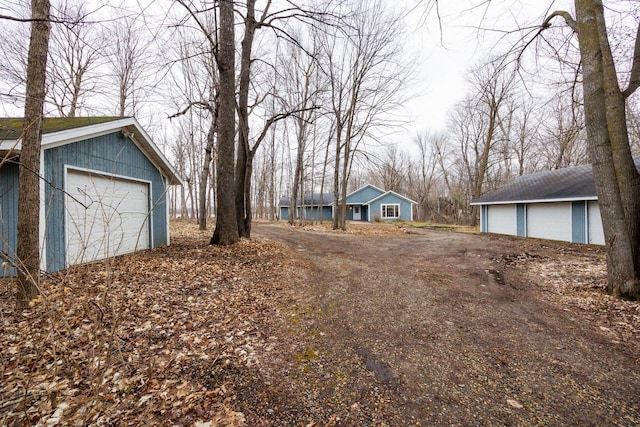 view of yard featuring a garage and an outbuilding