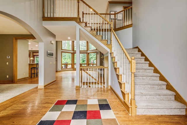17 Lake Ct, North Oaks, MN 55127 - stairway with a high ceiling, arched walkways, and wood finished floors