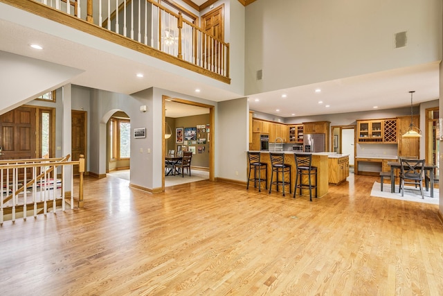 17 Lake Ct, North Oaks, MN 55127 - living area with arched walkways, a towering ceiling, light wood finished floors, stairway, and recessed lighting