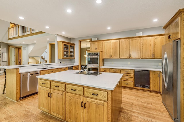 17 Lake Ct, North Oaks, MN 55127 - kitchen featuring black appliances, a kitchen island, light wood-style floors, a breakfast bar, and light countertops