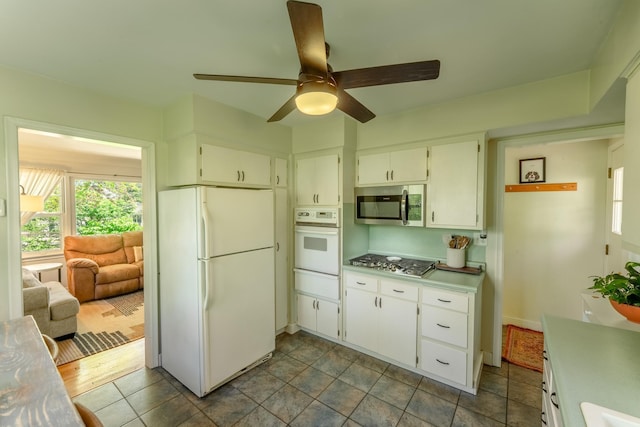 kitchen with appliances with stainless steel finishes, a warming drawer, ceiling fan, and healthy amount of natural light