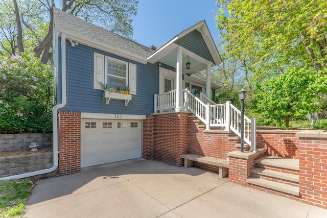 view of front of house featuring an attached garage, concrete driveway, brick siding, and roof with shingles