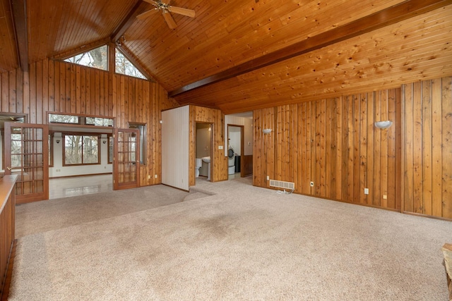 34126 County 115, Canton Twp, MN 55939 - unfurnished living room with beamed ceiling, carpet floors, a ceiling fan, wooden walls, and french doors