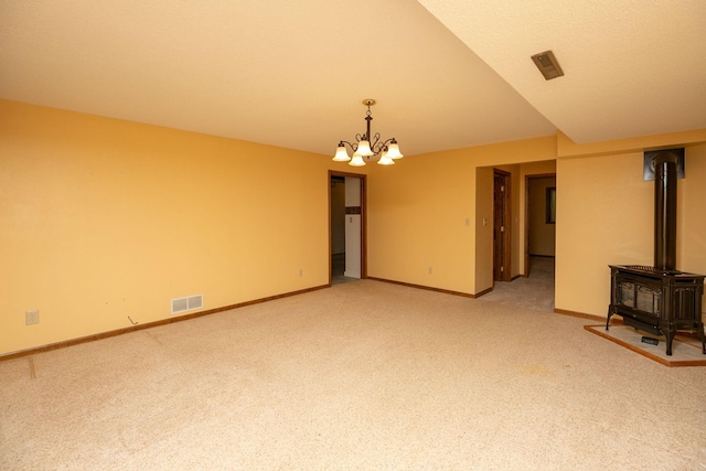 34126 County 115, Canton Twp, MN 55939 - empty room with a wood stove, light colored carpet, a chandelier, and baseboards