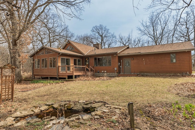 34126 County 115, Canton Twp, MN 55939 - back of house with a chimney, a yard, a sunroom, a wooden deck, and roof with shingles