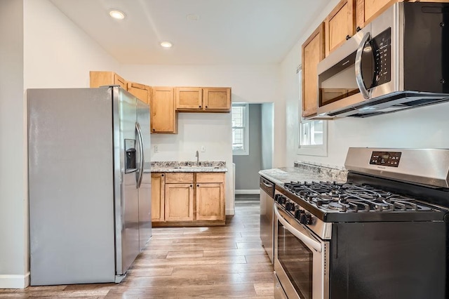 1907 University Ave NE, Minneapolis, MN 55418 - kitchen featuring stainless steel appliances, a sink, light wood-style flooring, baseboards, and recessed lighting