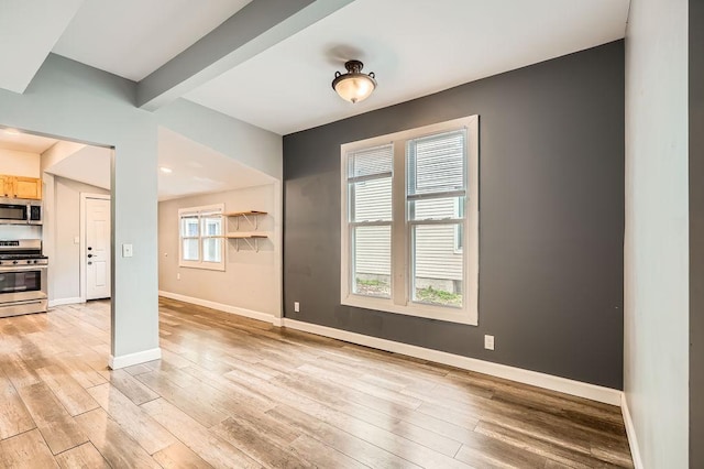 1907 University Ave NE, Minneapolis, MN 55418 - unfurnished room featuring light wood-type flooring, baseboards, and beam ceiling