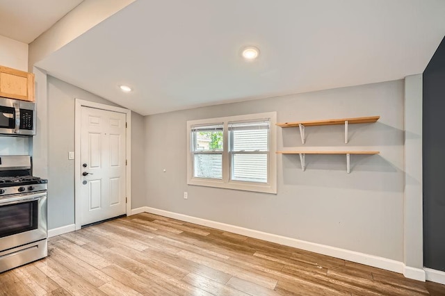 1907 University Ave NE, Minneapolis, MN 55418 - kitchen featuring appliances with stainless steel finishes, baseboards, light wood finished floors, lofted ceiling, and light brown cabinets