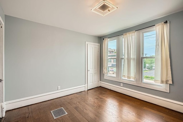 1907 University Ave NE, Minneapolis, MN 55418 - spare room with a baseboard radiator, dark wood-style flooring, and baseboards