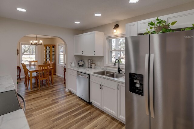 2730 State 371 SW, Pine River, MN 56474 - kitchen featuring a sink, arched walkways, an inviting chandelier, white cabinets, and appliances with stainless steel finishes