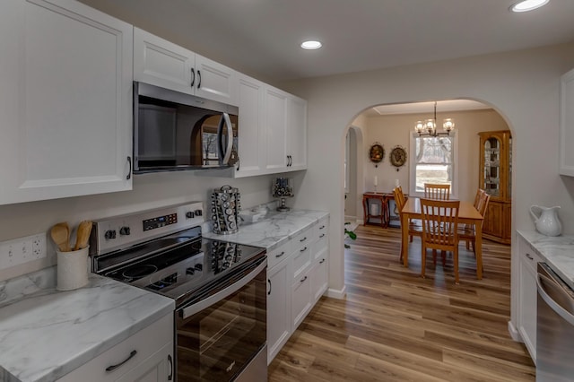 2730 State 371 SW, Pine River, MN 56474 - kitchen with arched walkways, light wood-style floors, white cabinets, and stainless steel appliances
