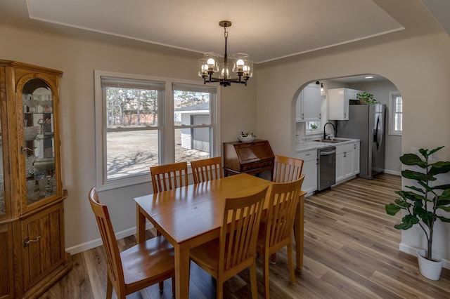 2730 State 371 SW, Pine River, MN 56474 - dining area featuring arched walkways, light wood-type flooring, baseboards, and an inviting chandelier