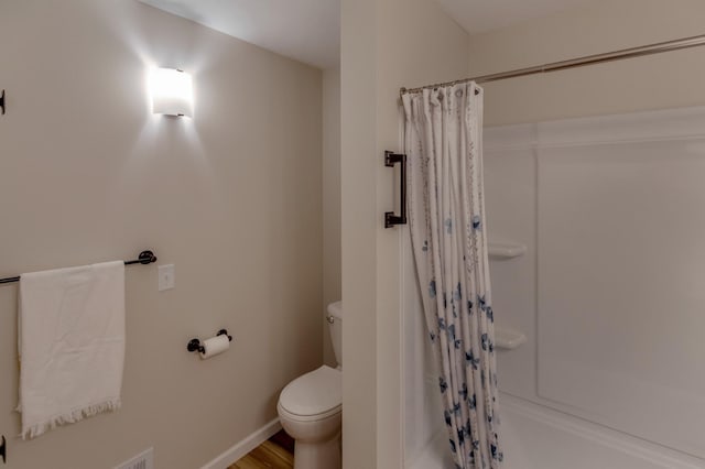 2730 State 371 SW, Pine River, MN 56474 - bathroom featuring baseboards, wood finished floors, a shower with curtain, and toilet