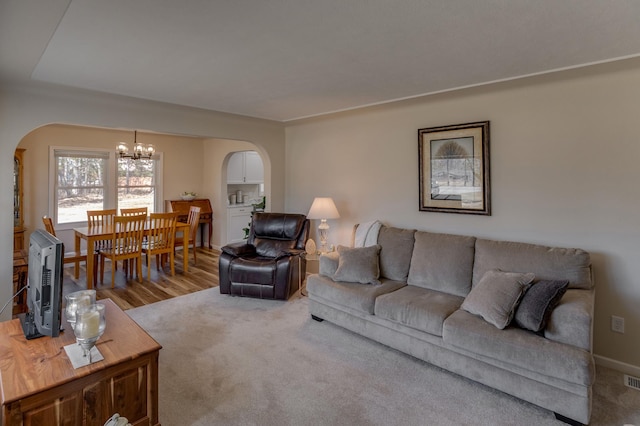 2730 State 371 SW, Pine River, MN 56474 - carpeted living room featuring arched walkways, visible vents, baseboards, and an inviting chandelier
