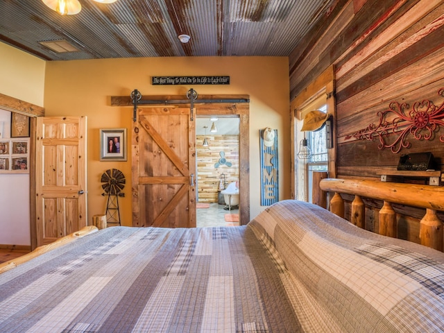 23660 Cap Endres Rd NE, Cass Lake, MN 56633 - bedroom featuring a barn door and wooden walls