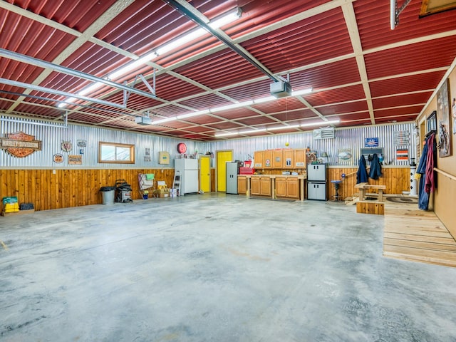 23660 Cap Endres Rd NE, Cass Lake, MN 56633 - garage featuring freestanding refrigerator, a garage door opener, and wood walls