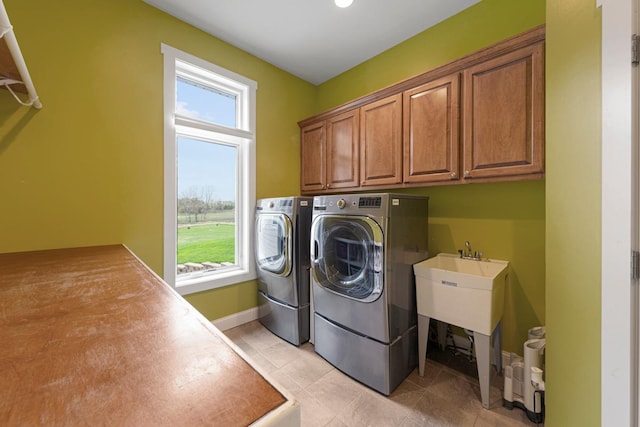6570 Chester Ave, Webster Twp, MN 55057 - laundry room with washer and dryer, baseboards, light tile patterned floors, and cabinet space
