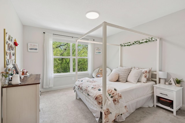 bedroom featuring light colored carpet and baseboards