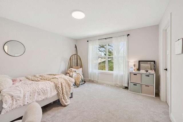 bedroom with light colored carpet, visible vents, and baseboards