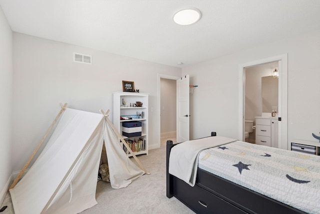 bedroom with light colored carpet, connected bathroom, visible vents, and baseboards
