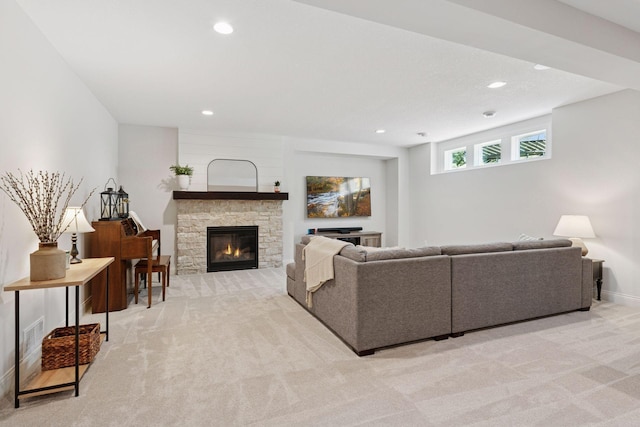 living room with light carpet, a stone fireplace, and recessed lighting