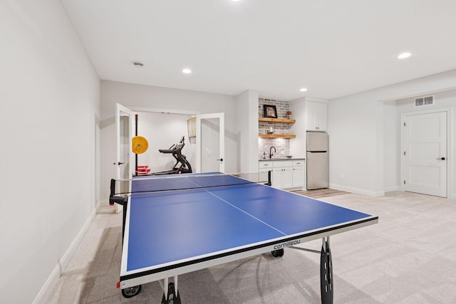 recreation room featuring indoor wet bar, visible vents, recessed lighting, light carpet, and baseboards