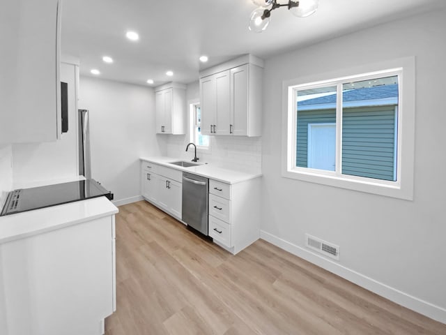 11601 Wren St NW, Coon Rapids, MN 55433 - kitchen with dishwasher, a sink, baseboards, white cabinets, and recessed lighting