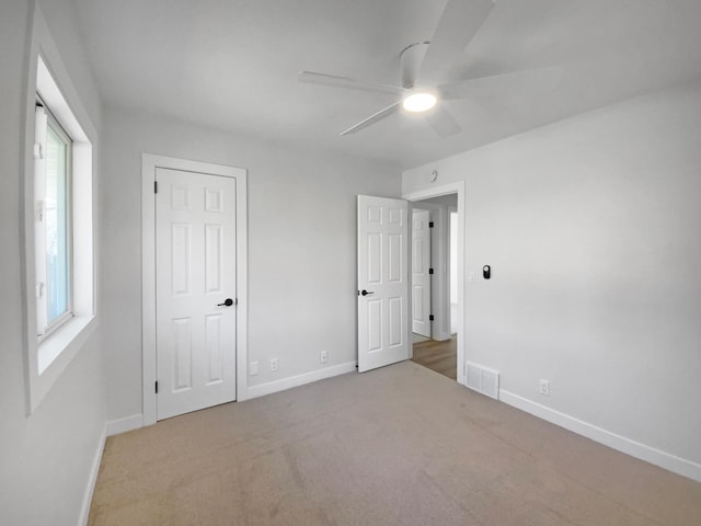 11601 Wren St NW, Coon Rapids, MN 55433 - unfurnished bedroom featuring baseboards, carpet, multiple windows, and ceiling fan